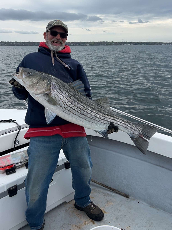 Week 1 Boat winner Eugene Silva Jr. of Rumford, RI with his striped bass